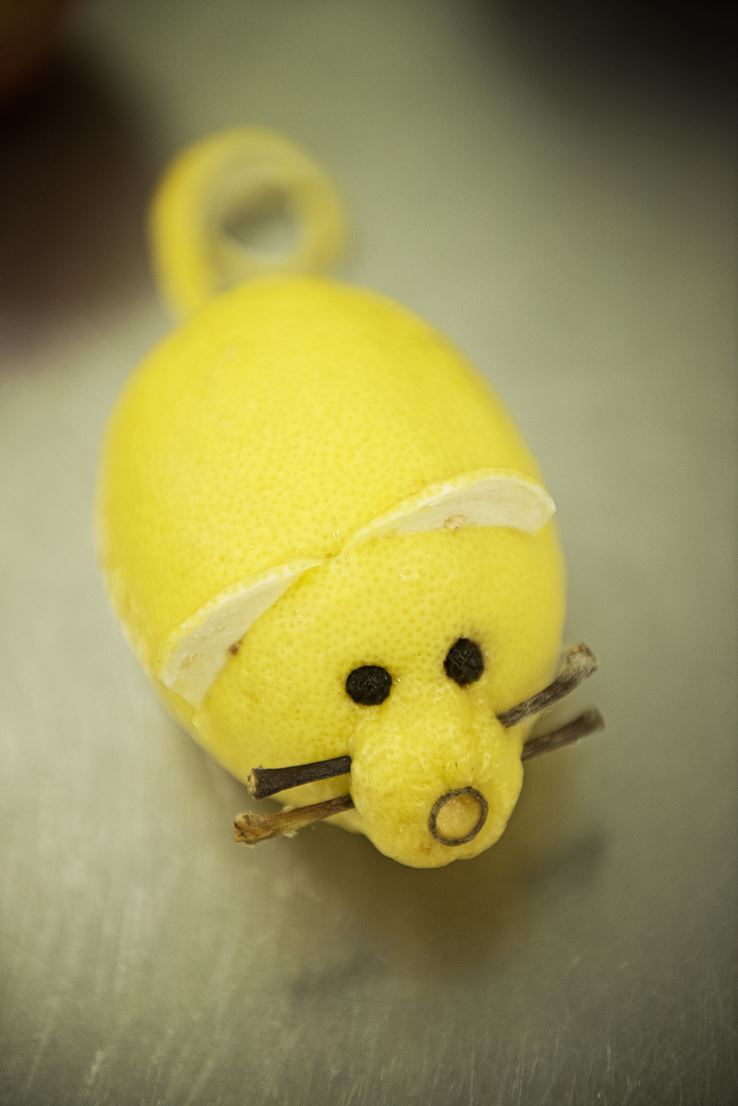 En citron er blevet skåret ud som en mus med hale, knurhår, ører og øjne.